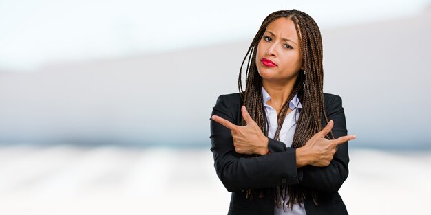 Portrait of a young black business woman confused and doubtful man