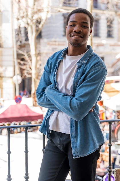 Portrait of young black ethnic woman at balcony railing at home in the city lifestyle smiling