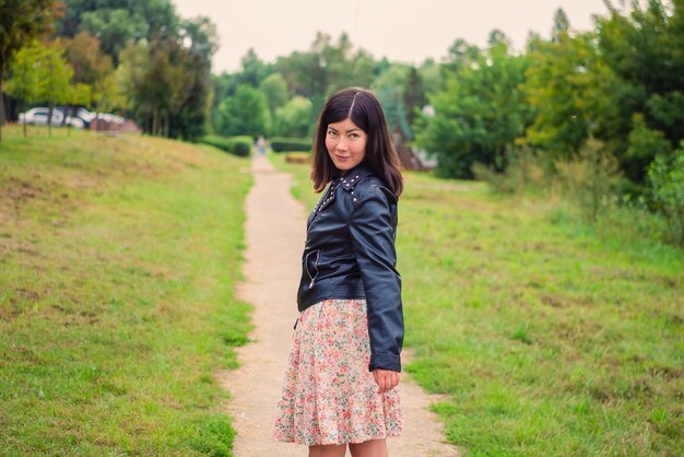 Portrait of a young black-haired girl in the park                               person