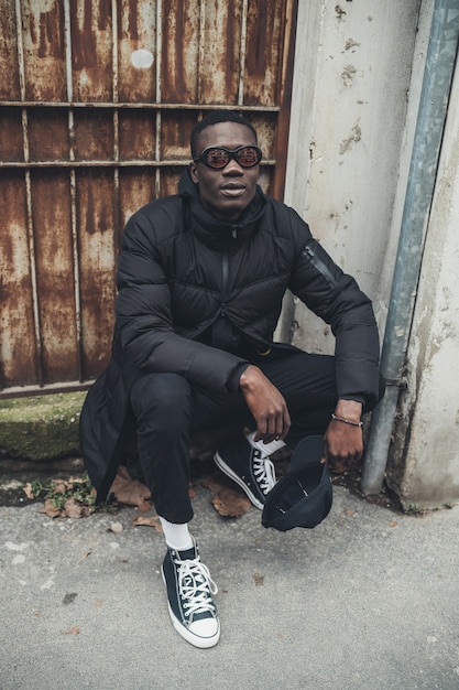 Portrait of young black man sitting in the street and looking camera