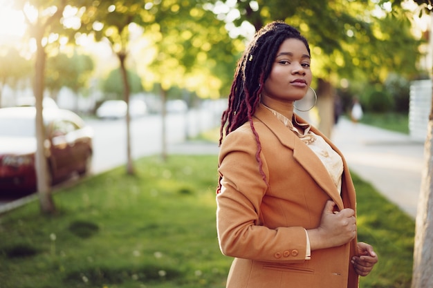 Портрет молодой черной женщины, стоящей на улице