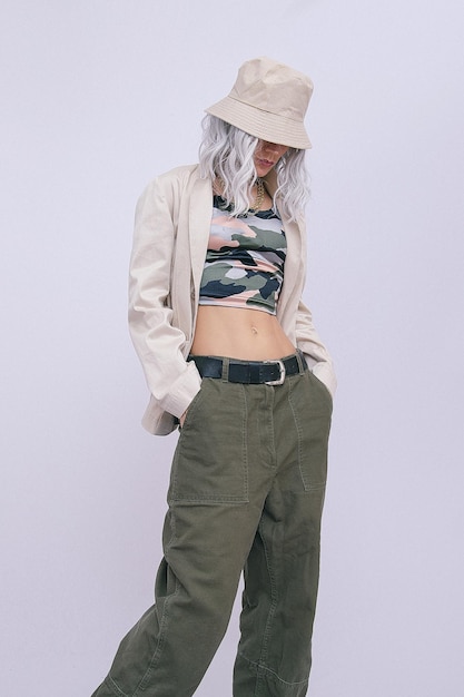 Portrait of young blond girl wearing military fashionable street style clothing and trendy platform boots. Minimalist fashion