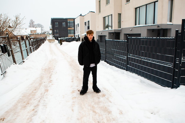 Portrait of young blond man on winter European street