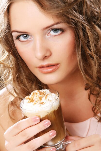 Portrait of young blond woman holding cafe latte cup