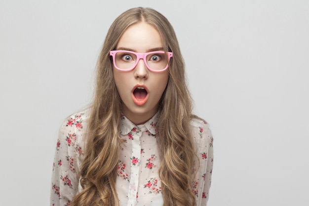 Portrait young blonde girl looking at camera with surprised face and open mouth