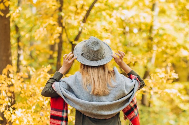 Photo portrait of a young blonde woman in the autumn forest