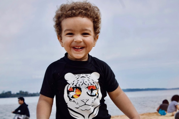 Photo portrait of young boy standing at beach