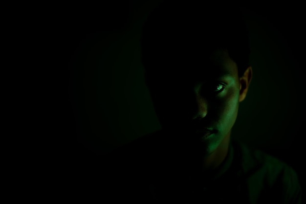 Photo portrait of young boy staring in dark