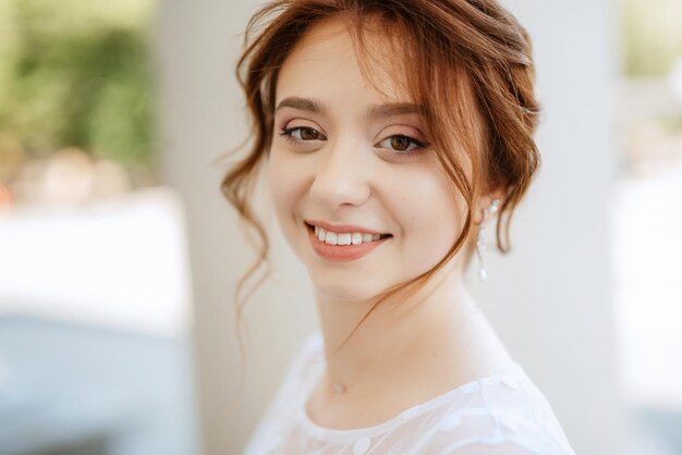 Portrait of a young bride girl in a light dress in an urban environment