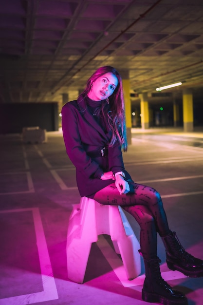 Portrait of young brunette Caucasian model at night in an underground parking lot