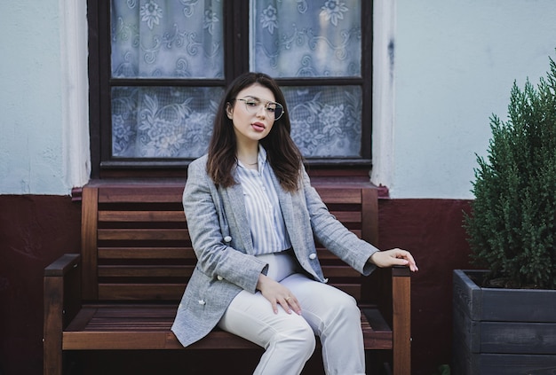 Portrait of young brunette long hair girl sitting on the street