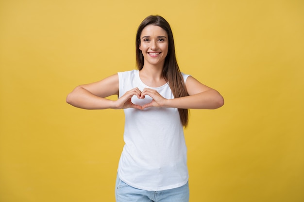 Portrait of young, brunette, pretty girl in white shirt and jeans showing with her finger 