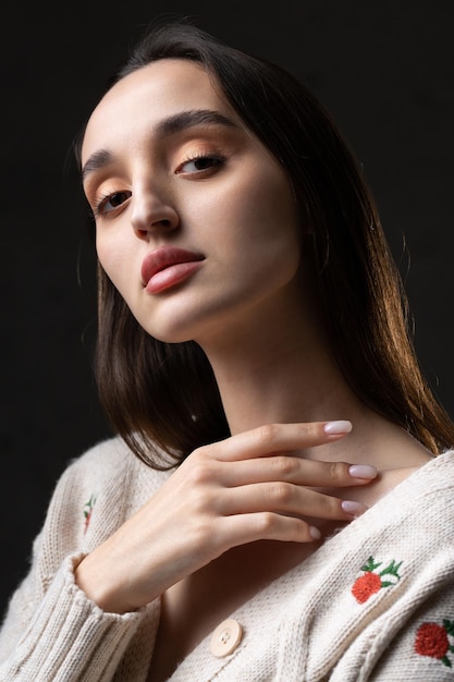 Portrait of a young brunette with long hair in the studio Dramatic photo in dark colors