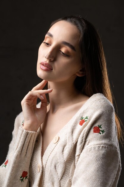 Portrait of a young brunette with long hair in the studio Dramatic photo in dark colors