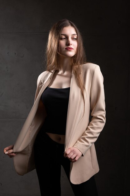 Portrait of a young brunette with long hair in the studio Dramatic photo in dark colors