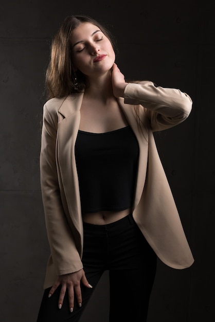 Portrait of a young brunette with long hair in the studio Dramatic photo in dark colors