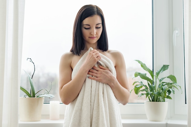 Portrait of young brunette woman in bath towel