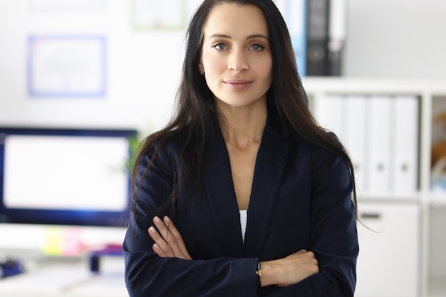 Portrait of young brunette woman in business suit in office implementation of women in business