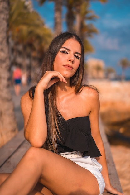 Portrait of a young brunette woman enjoying her day at the coast by the beach