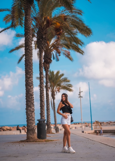 Portrait of a young brunette woman enjoying her day at the coast by the beach