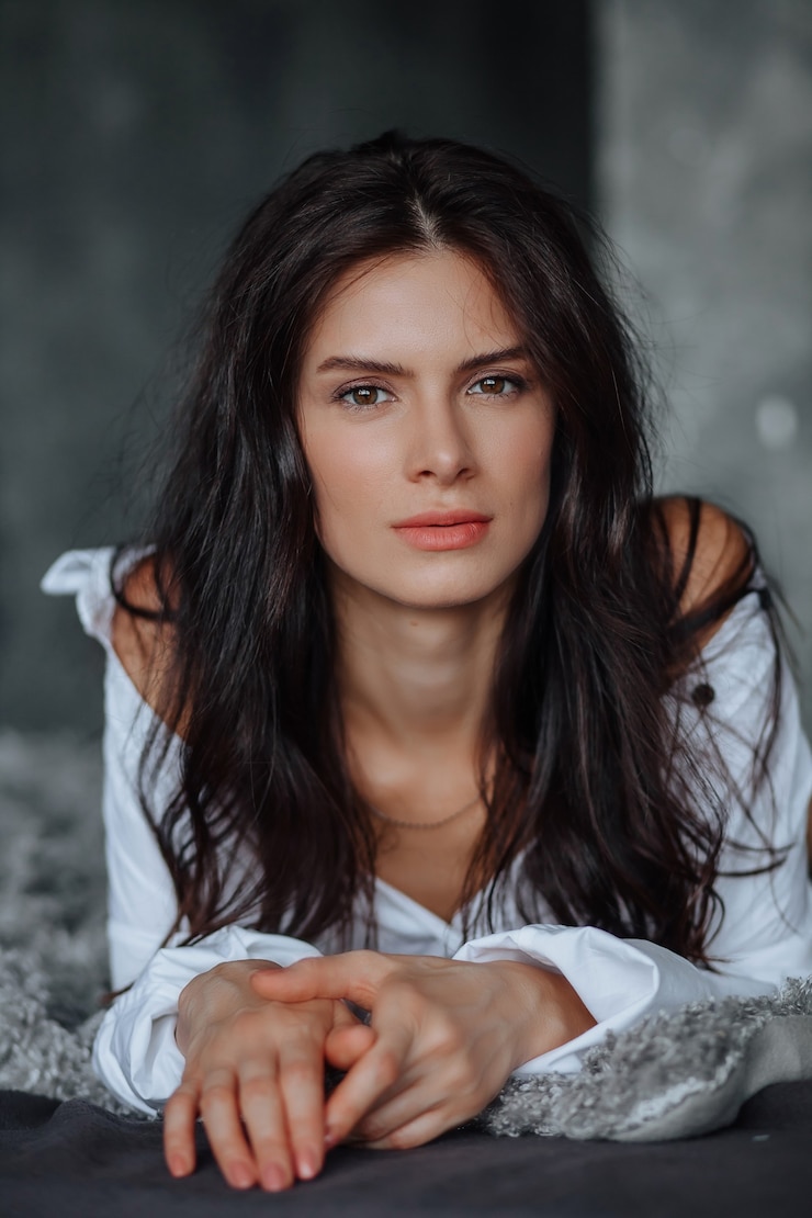 Фотография портрет молодой женщины брюнетки на светлом фоне