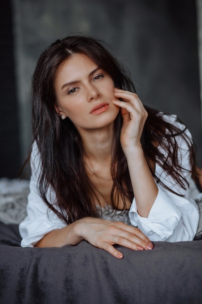 Portrait of young brunette woman on a light background