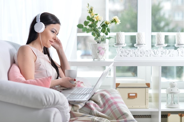 Portrait of a young brunette woman using laptop