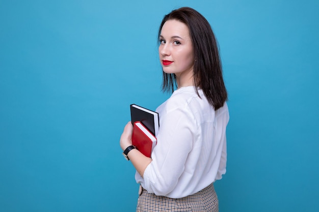 Portrait of a young brunette woman with a black and red diary