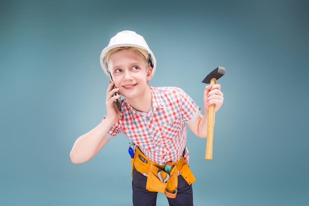 Portrait of a young builder in a helmet and a tape measure in his hand