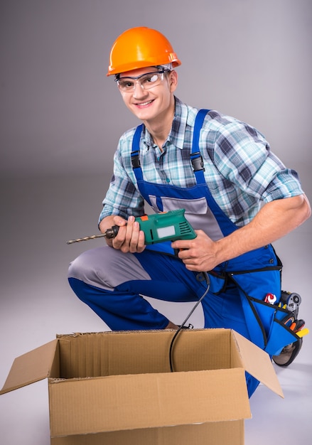 Portrait of a young builder with tools in hand.