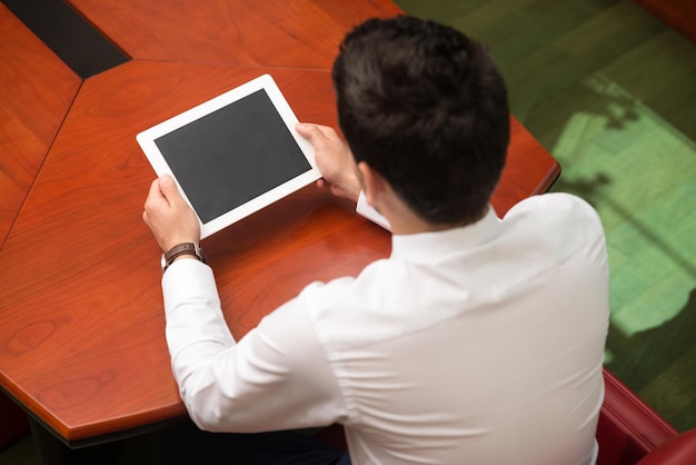 Portrait Of A Young Business Man Using A Touchpad In The Office