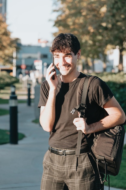 Portrait of a young business student making a phone call while smiling, copy space, notebook student business concept, modern design business buildings