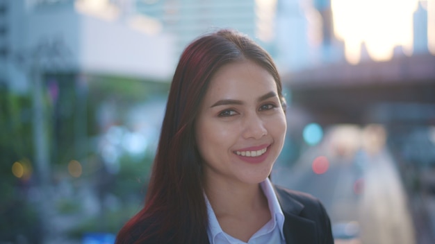 Portrait of a young business woman is smiling in city 