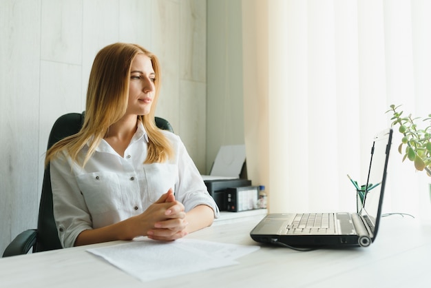 Ritratto di una giovane donna d'affari utilizzando laptop in ufficio