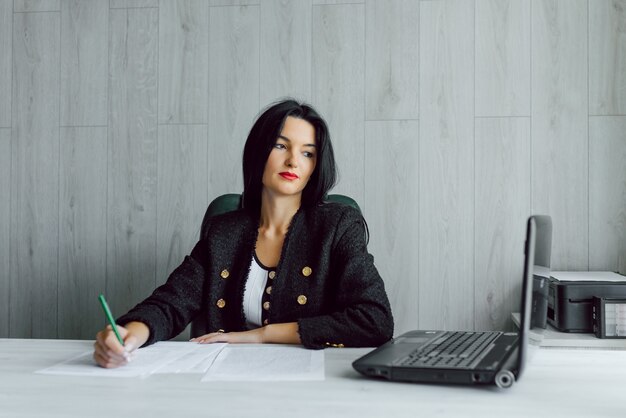 Portrait of a young business woman using laptop at office