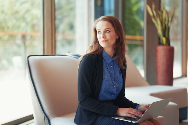 Portrait of a young business woman using laptop at office