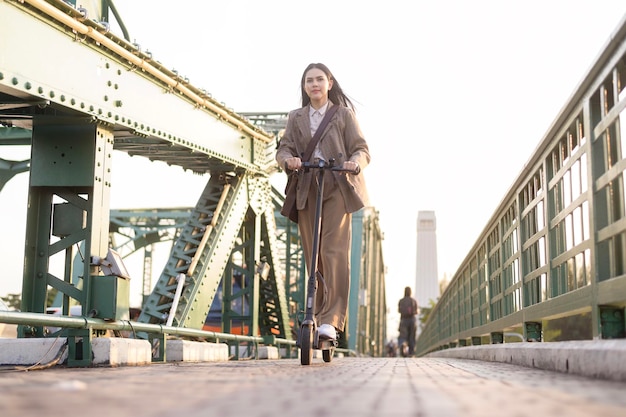 Portrait of young business woman with an electric scooter to work o