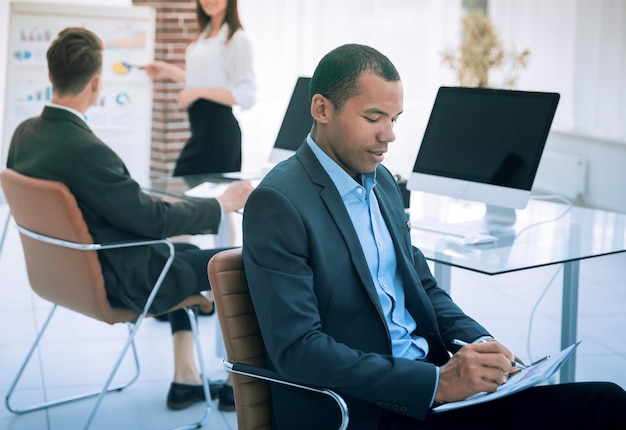 Portrait of a young businessman on background of office