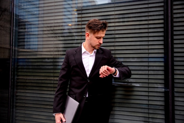 Portrait of a young businessman in a business center with a laptop in his hands