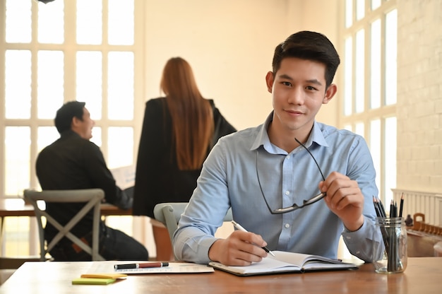 Portrait young businessman in coworking space 