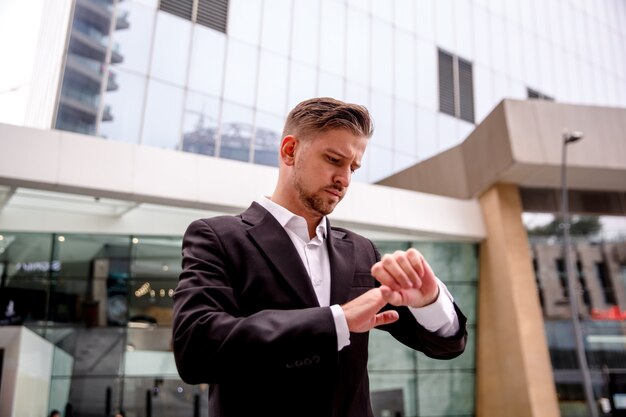 Portrait of a young businessman looking at his watch