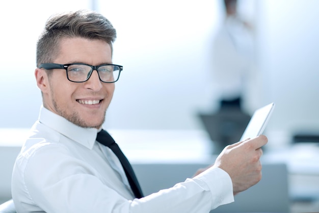 Portrait of young businessman in officeBusinessman using tablet computer