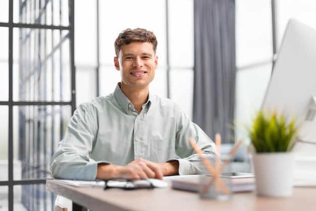 Photo portrait of young businessman sitting at his desk in the office