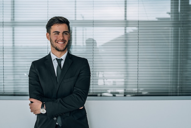 portrait of young  businessman smiling at the airport with suit