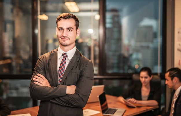 Portrait of young businessman smiling working on modern loft office at nigh.