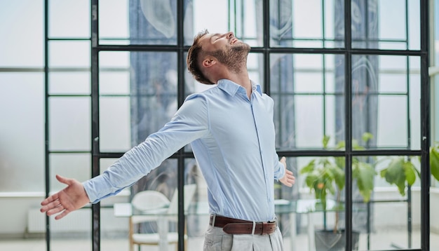 Portrait of young businessman wearing and standing outside conference room