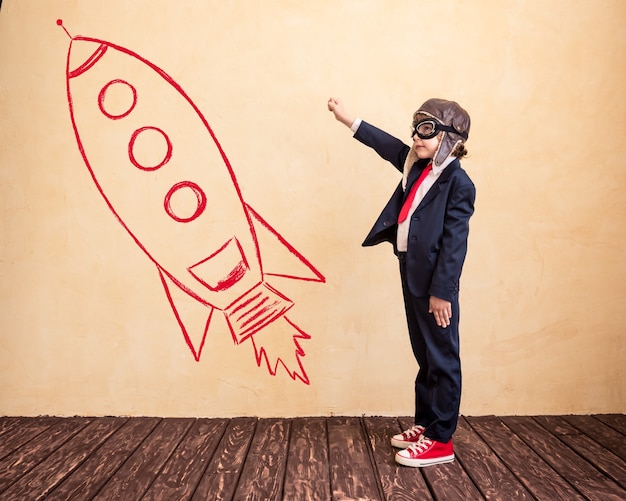 Portrait of young businessman with drawn rocket Success creative and startup concept