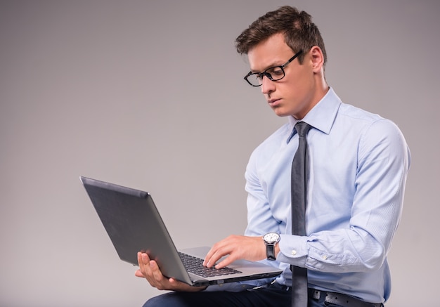 Portrait of a young businessman with a laptop.