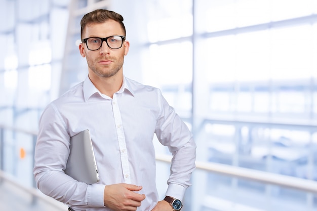 Portrait of young businessman with laptop