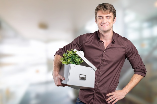 Portrait Of Young Businessman with Plant In Cardboard Box